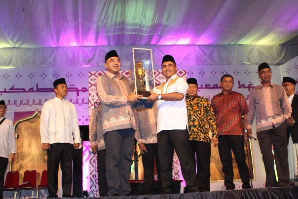 Bupati Tangerang A. Zaki Iskandar menyerahkan tropi juara umum MTQ ke-46 kepada Camat Legok, Dadan Gandana.